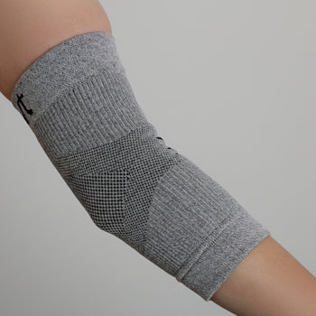 Grey Elbow Sleeve/Brace on a Woman’s Arm with a Natural Background